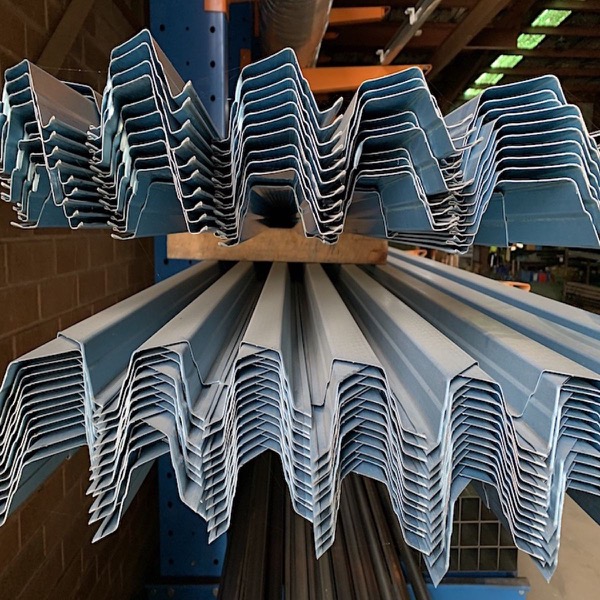 Bundles of profiled steel sections stacked across a storage rack