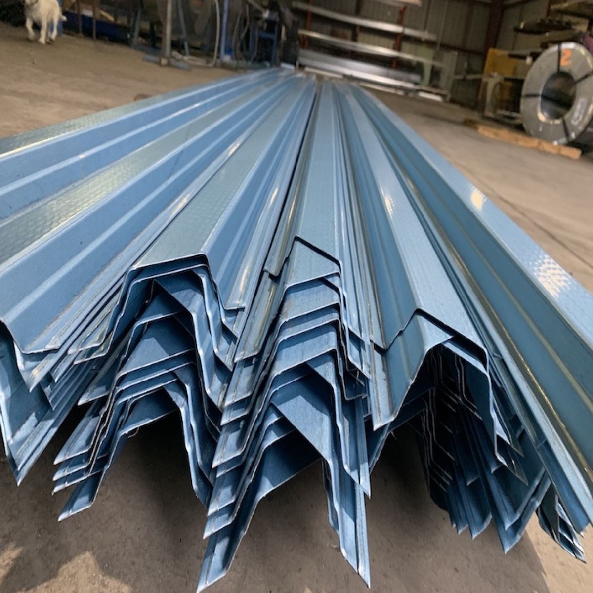A stack of galvanised purlin sections on the shed floor