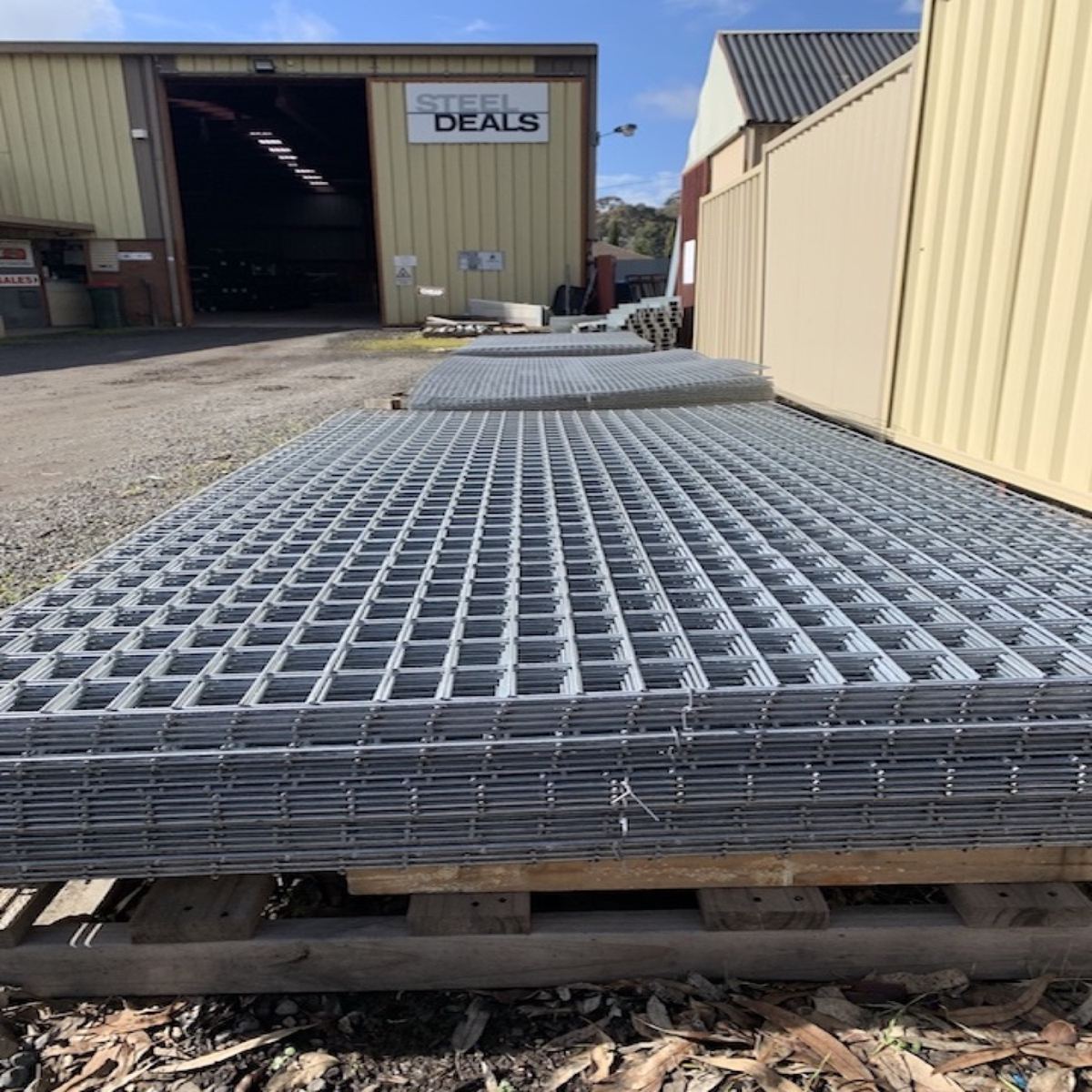 Sheets of reinforcing mesh stacked on pallets in the yard