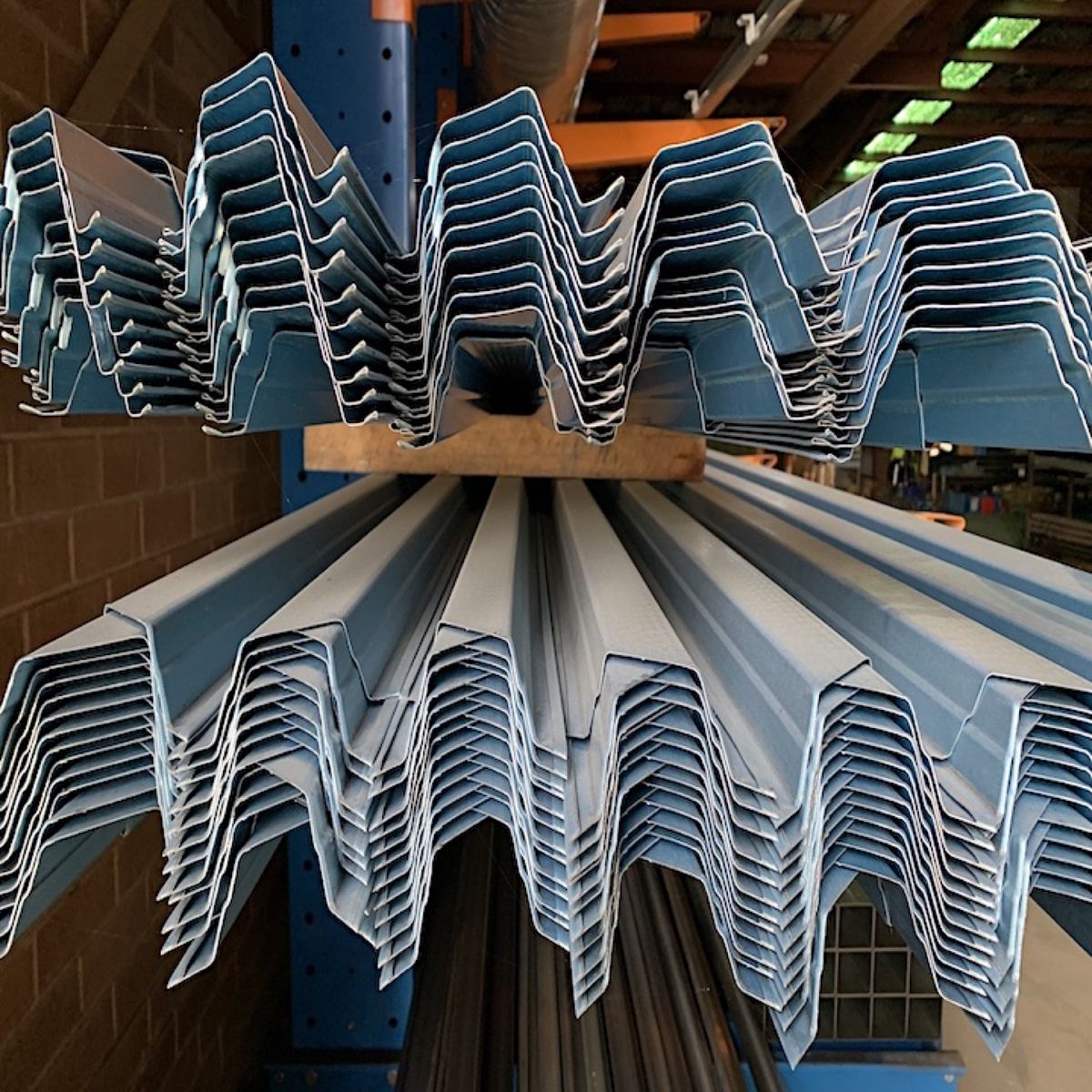 Bundles of profiled steel sections stacked across a storage rack